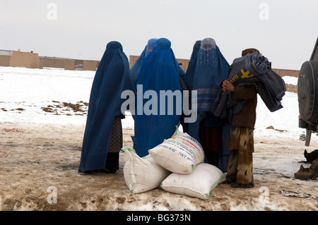 Les familles afghanes pauvres reçoivent des fournitures de secours à froid pour les aider dans l'hiver dans le nord de l'Afghanistan. Banque D'Images