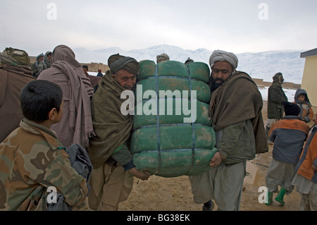 Les familles afghanes pauvres reçoivent des fournitures de secours à froid pour les aider dans l'hiver dans le nord de l'Afghanistan. Banque D'Images