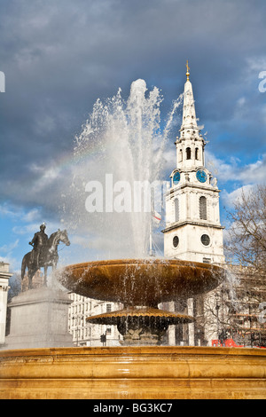 Fontaine à Trafalgar Square avec St Martin-in-the-Fields church et statue du roi George IV à cheval, Londres Banque D'Images