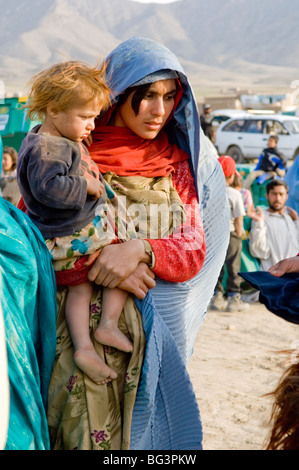 Mère afghane dévoilés avec sa fille en attente sur le relief à Bagram, en Afghanistan. Banque D'Images