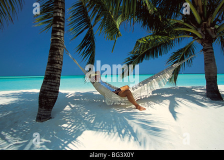 Man relaxing on un hamac sur la plage, Maldives, océan Indien, Asie Banque D'Images