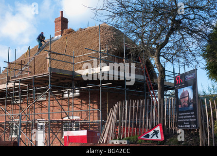 Construire une nouvelle maison au toit de chaume est presque terminée en Urchfont Wiltshire UK Vue à partir de la voie publique Banque D'Images