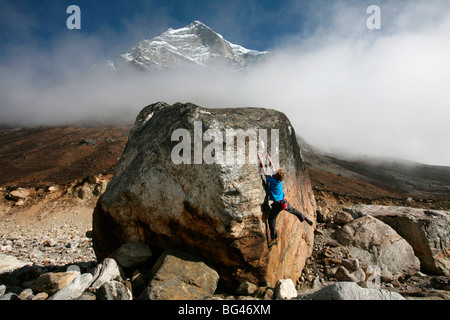 Climber aborde un problème de blocs sur la moraine glaciaire à Tangnag, région de Khumbu, Népal, Himalaya, Asie Banque D'Images