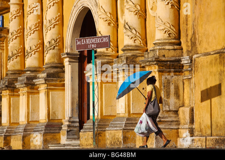 Nicaragua, Leon, Femme avec parapluie bleu à pied de Iglesia de la Recoleccion Banque D'Images