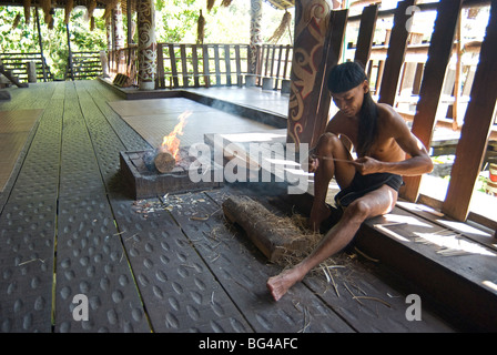 Orang Ulu tribesman tailler le bois dans la maison longue, Village Culturel de Sarawak Kuching, Sarawak, Malaisie, Bornéo, Malaisie Banque D'Images