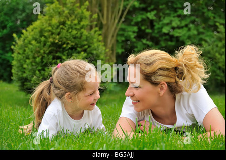 Jeune mère et fille portant sur l'herbe Banque D'Images