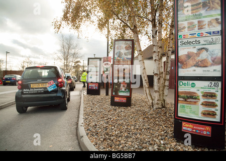 Une voiture Smart Dominos Pizza dans la file d'attente à un McDonalds drive thru Banque D'Images