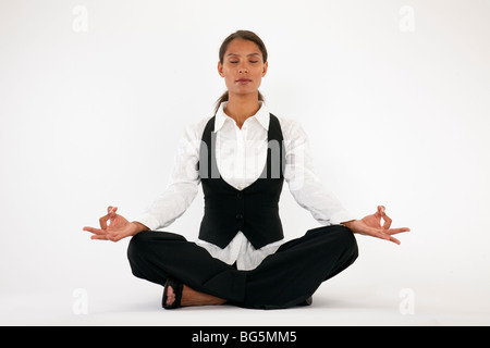 Young woman sitting cross legged et méditer. Encadrée horizontalement shot. Banque D'Images