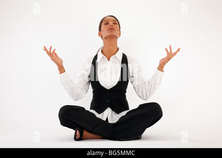 Young woman sitting cross legged et méditer. Encadrée horizontalement shot. Banque D'Images