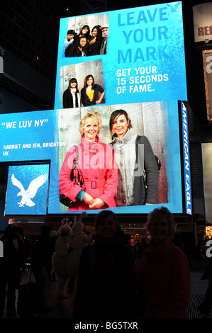 Photographies de shoppers à l'American Eagle store sont diffusées sur un écran géant à Times Square New York USA Banque D'Images