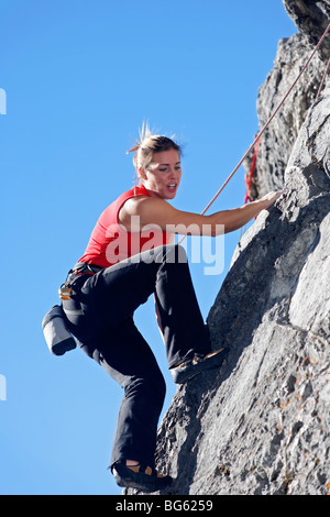 Femme climber sur rock face contre ciel bleu, Banff, Banff National Park, Alberta, Canada Banque D'Images