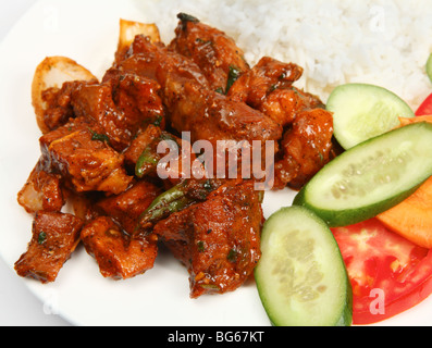 Un repas traditionnel indien de chili au bœuf curry, servi avec du riz blanc bouilli et une salade de concombre, tomates et carottes. Banque D'Images