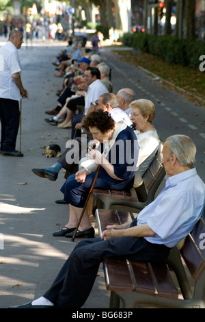 Les personnes âgées se sentent tranquilles et mangent des collations pendant la sieste sur les bancs du parc dans un parc de la ville près de la Sagrada Familia Barcelone Catalogne Espagne Banque D'Images