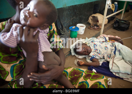 Un enfant souffrant du paludisme se trouve sur le sol de l'hôpital de Amuria, en Ouganda. Banque D'Images