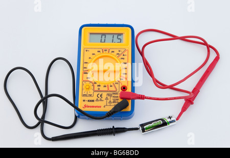 Multimètre numérique, mesurer la tension de batterie AA sur un fond blanc. Banque D'Images