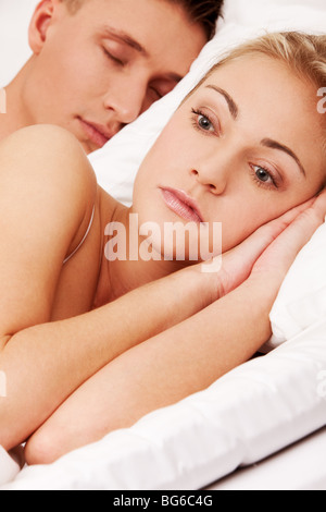 Femme souffrant de l'insomnie, tandis que son mari est en train de dormir Banque D'Images