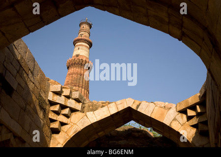 Le Qutb Minar à Delhi, Inde, vu à travers les vestiges de l'quwwat-ul-Islam mosquée. Banque D'Images