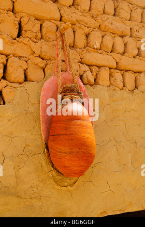 Une cruche pleine d'eau suspendu à un mur de briques. d'une maison dans la ville de Al Qasr à Dakhla oasis, à l'ouest de l'Égypte Banque D'Images
