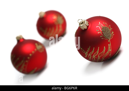 Trois boules de Noël rouge isolé sur fond blanc. Vue d'inclinaison peu profond, DOF. Banque D'Images