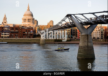 Un bateau de patrouille de la Police de la Tamise en passant sous l'Millenium Bridge à Londres. Banque D'Images