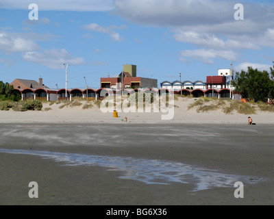 Sur la plage de Puerto Madryn, Patagonie, Argentine ; la marée basse, vent, quartier résidentiel face à l'océan Banque D'Images