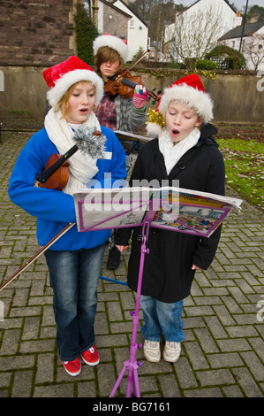 Carol singers. Trio de jeunes filles des chants de Noël à l'extérieur au Festival d'hiver de l''Usk Usk Monmouthshire South Wales UK Banque D'Images