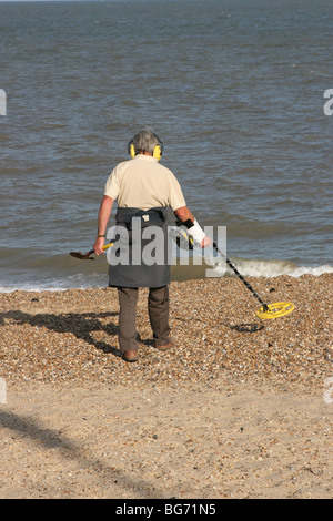 Man Walking on beach avec détecteur de métal Banque D'Images