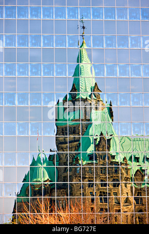 Réflexions de l'Édifice de la Confédération dans les fenêtres d'un bâtiment moderne dans la ville d'Ottawa, Ontario, Canada. Banque D'Images