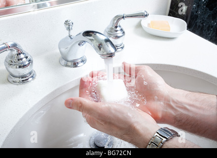 Close up of hands être lavées avec du savon dans la salle de bains lavabo Banque D'Images