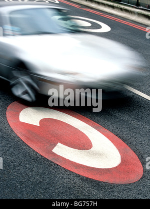 Une voiture passe sur une London congestion charge la signalisation horizontale. Banque D'Images