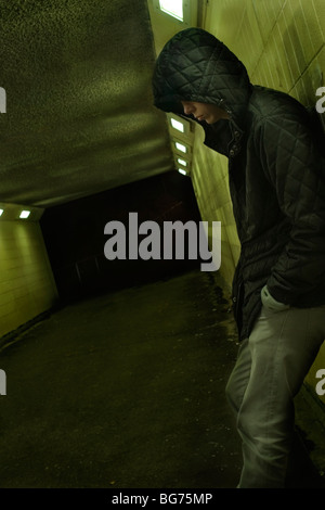 Teenage boy leaning against wall du métro la nuit, Londres, UK Banque D'Images