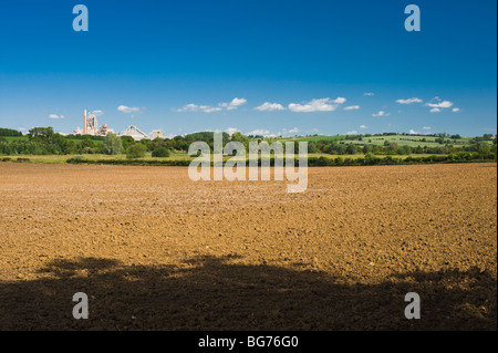 Champ labouré sur la frontière de Northamptonshire et Rutland, avec du ciment Ketton fonctionne en arrière-plan Banque D'Images