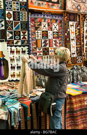 Le Pérou, la Vallée Sacrée, Pisac Village, les textiles pour la vente au marché local, les touristes à la recherche d'acheter Banque D'Images