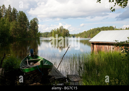 Ancienne tour de bateaux finlandais , en rondins , et un barque en bois / skiff / canot au bord du lac Etelä-Konnevesi , Finlande Banque D'Images