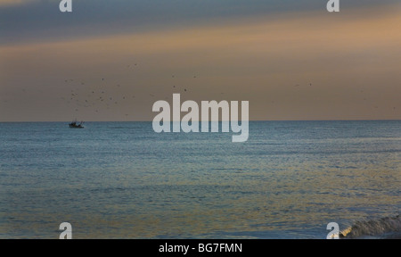 Bateau de pêche de partir d'Albeburgh beach dans un coucher de soleil d'hiver Banque D'Images