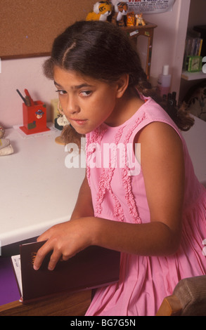 Petite fille à la furtive comme elle lit le journal intime de quelqu'un d'autre Banque D'Images