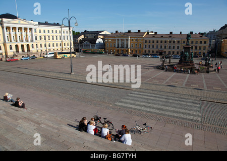 La Finlande, Helsinki, Helsingfors, Place du Sénat, les touristes assis sur les marches de la Cathédrale Banque D'Images