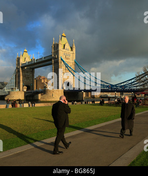 Les hommes d'affaires en passant devant le Tower Bridge, Londres, Angleterre, Royaume-Uni. Banque D'Images