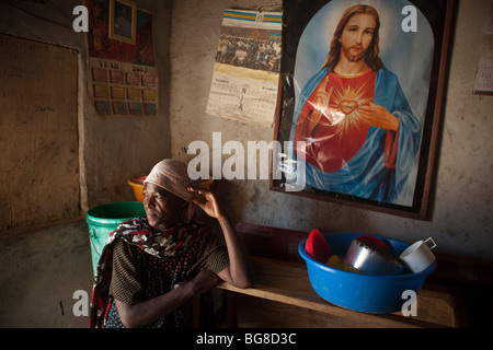 Une femme séropositive pairs hors de la porte de sa maison à Mererani, en Tanzanie. Banque D'Images