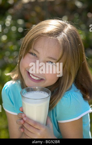 Girl holding verre de lait à l'extérieur Banque D'Images