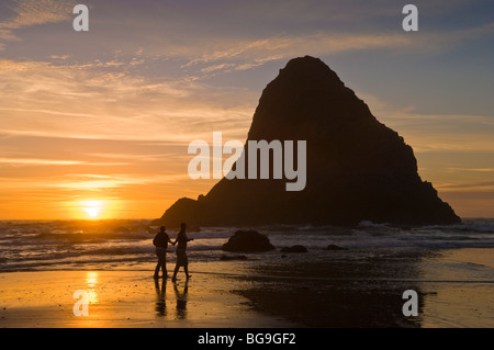 Couple sur la plage au coucher du soleil, Whaleshead Plage, côte de l'Oregon. Banque D'Images