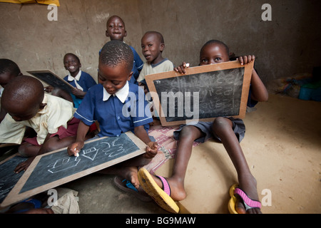 Les jeunes enfants de dessiner sur les tableaux dans un orphelinat à Amuria, Ouganda, Afrique de l'Est. Banque D'Images