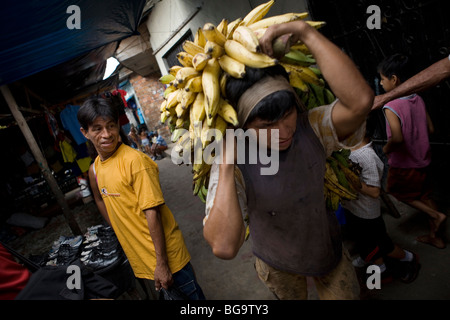 Docker transporte les bananes sur le marché de Puerto Belen, un quartier de Lima au Pérou, du bassin amazonien. Banque D'Images