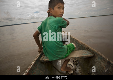 Un garçon lignes son bateau le long de la rivière Amazone près de la ville d'Iquitos, dans le nord-est du Pérou . Banque D'Images