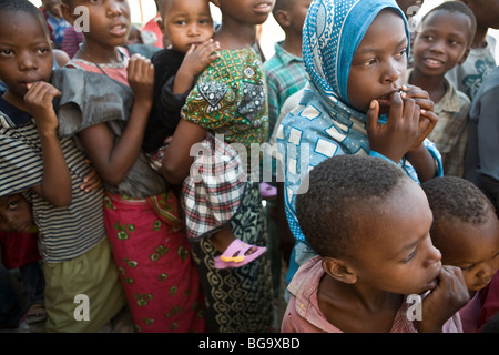 Les enfants attendent dans une file d'attente de distribution de nourriture à Mererani, la Tanzanie, la seule source connue de la gemme Tanzanite. Banque D'Images