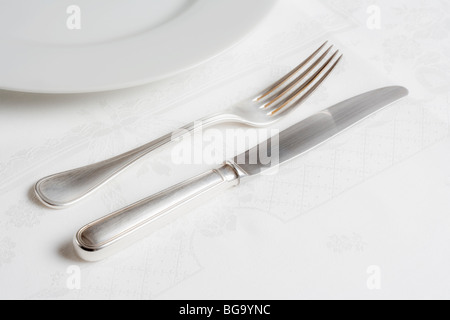 Réglage table élégante avec l'argenterie sur un tissu blanc Banque D'Images