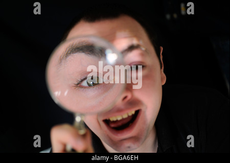 À travers une loupe cette personne s'amuse à déformer son image. Photo par Jim Holden. Banque D'Images