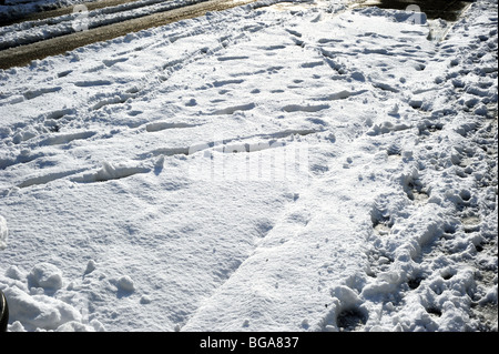 Pneu de voiture et les empreintes laissées dans la neige après une lourde chute à Brighton Banque D'Images