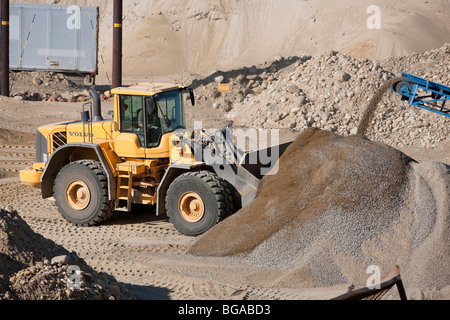 Chargeur frontal Volvo chargeant du gravier dans un bac à sable dans une zone d'exploitation de carrières de sable, Finlande Banque D'Images