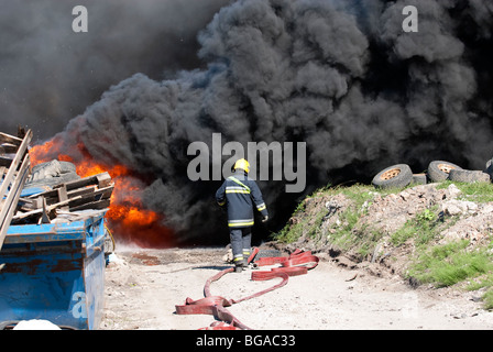 De grands panaches de fumée noire à grand incendie de pneus industriels Banque D'Images